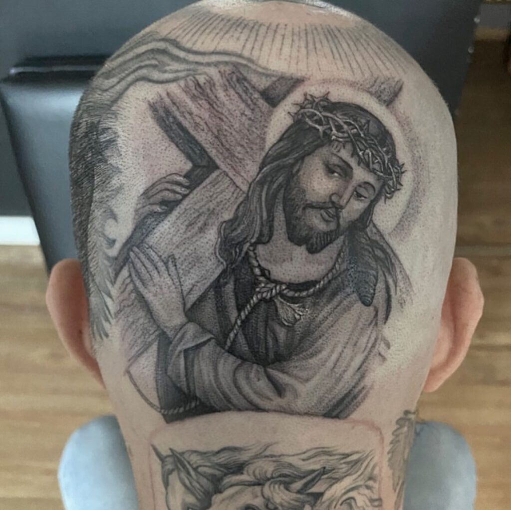 Jesus carrying a cross, done as a single needle tattoo on the back of a head