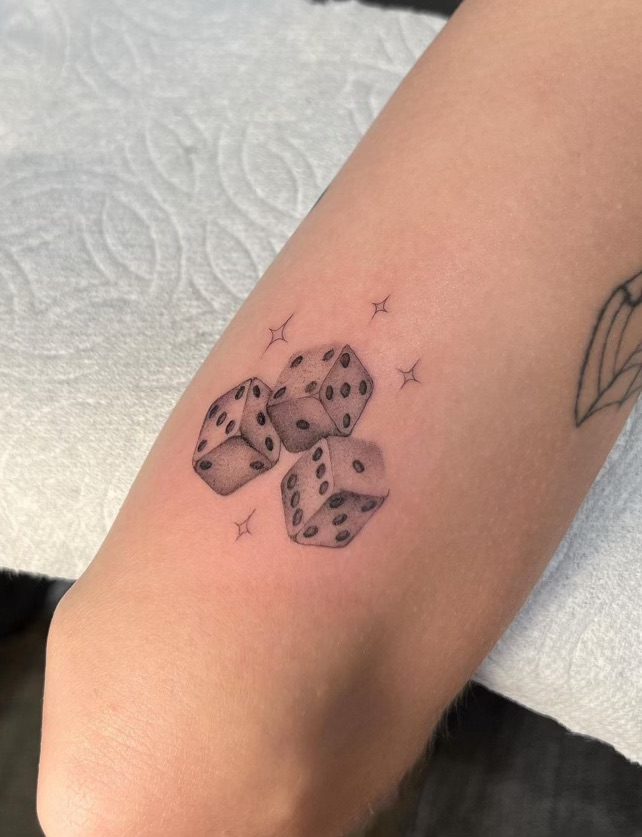 Single needle tattoo of 3 dice and some stars