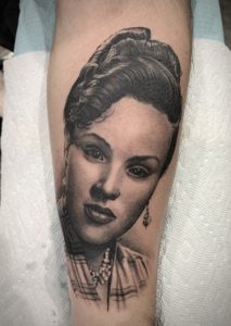 A black and grey portrait tattoo of a beautiful woman's face