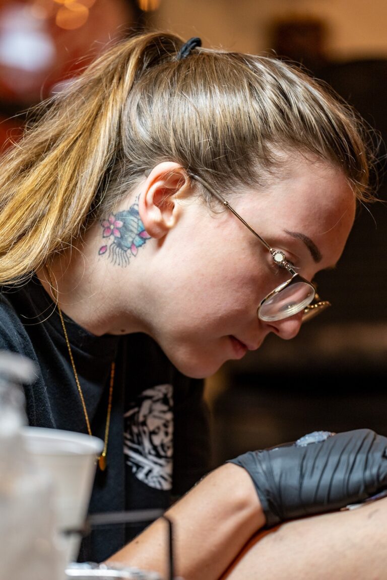 Action portrait of Tiff Saxey tattooing