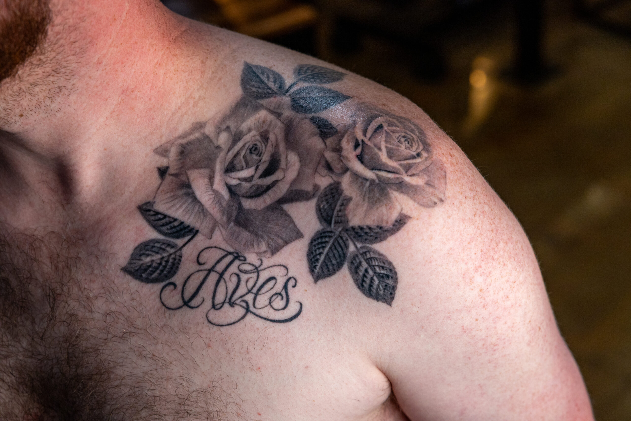 Black and greay realism tattoo of roses on a shoulder