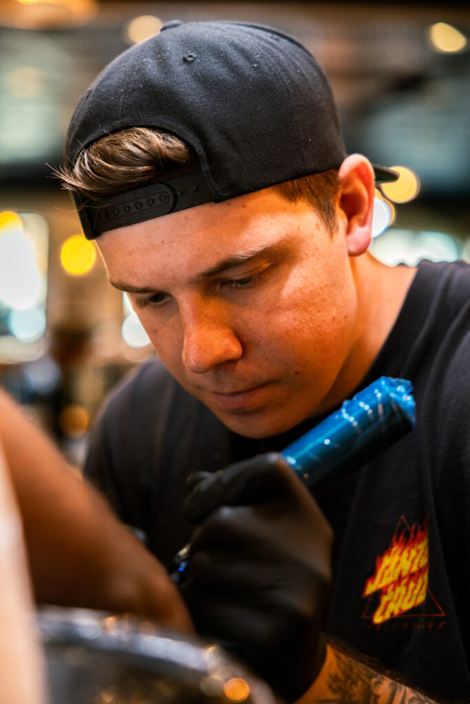 Action portrait of Tyler Brown tattooing